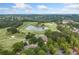 An aerial view of a golf course, pond, clubhouse, and picturesque landscape in a residential community at 6219 Creekstone Path, Cumming, GA 30041