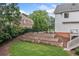 Well-manicured backyard featuring stone terracing, lush greenery, and a basketball court, ideal for outdoor enjoyment at 6219 Creekstone Path, Cumming, GA 30041