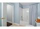 Bright bathroom with a combination shower and tub featuring blue walls and tiled floors at 6219 Creekstone Path, Cumming, GA 30041