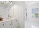 Bright bathroom featuring a white vanity, updated fixtures, a glass door shower, and natural light from the window at 6219 Creekstone Path, Cumming, GA 30041