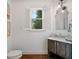 Charming powder room with dark vanity, marble countertop, decorative mirror, and white plantation shutters at 6219 Creekstone Path, Cumming, GA 30041
