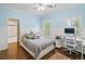 Bright bedroom featuring hard wood floors, ceiling fan, and a dedicated desk area with a view at 6219 Creekstone Path, Cumming, GA 30041