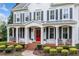 Charming white facade with covered porch, brick steps, and manicured landscaping at 6219 Creekstone Path, Cumming, GA 30041