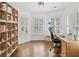 Bright home office with a comfortable desk, chair, built-in bookshelf, and natural light from window at 6219 Creekstone Path, Cumming, GA 30041