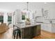 Bright kitchen with white cabinetry, granite countertops, a subway tile backsplash, and seating at the island at 6219 Creekstone Path, Cumming, GA 30041