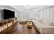 Bright, open living room boasts modern lighting, wood floors, a large sectional couch, and lots of natural light at 6219 Creekstone Path, Cumming, GA 30041