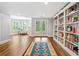 Inviting living room with hardwood floors, a colorful rug, bookshelves, and french doors leading to the backyard at 6219 Creekstone Path, Cumming, GA 30041
