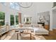 Bright living room with large windows, an open floor plan, and view into the kitchen and dining area at 6219 Creekstone Path, Cumming, GA 30041