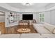 Spacious living room features a large sectional couch, stylish decor, wood floors, and lots of natural light at 6219 Creekstone Path, Cumming, GA 30041