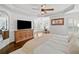 Bright bedroom showcasing a flat screen TV, ceiling fan, and an inviting, comfortable bed at 6219 Creekstone Path, Cumming, GA 30041