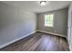 A cozy bedroom with a window for natural light and wood-look laminate flooring at 1753 Cahoon Sw St, Atlanta, GA 30310