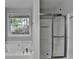 A bathroom with a soaking tub, stand up shower, and window at 1965 Sterling Creek Ct, Snellville, GA 30078