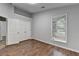 This bedroom features hardwood floors, a window, and closet space at 1965 Sterling Creek Ct, Snellville, GA 30078