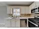 Bright kitchen features white cabinets, tile floors, and stainless steel appliances at 1965 Sterling Creek Ct, Snellville, GA 30078