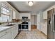 A kitchen with white cabinets, stainless steel appliances, and neutral-toned tile flooring at 1965 Sterling Creek Ct, Snellville, GA 30078