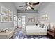 This main bedroom features a ceiling fan, decorative rug and artwork, and hardwood-style floors at 1965 Sterling Creek Ct, Snellville, GA 30078