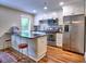 Modern kitchen with stainless steel appliances, white cabinets, and a sleek breakfast bar at 2210 Cumberland Se Ct, Smyrna, GA 30080