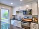 Bright kitchen featuring granite countertops, subway tile backsplash, and stainless steel appliances at 2210 Cumberland Se Ct, Smyrna, GA 30080