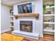 Living room featuring a fireplace with a wooden mantel, built-in shelves, and hardwood floors at 2210 Cumberland Se Ct, Smyrna, GA 30080