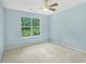 This bedroom has light blue walls, carpet, a window, and a ceiling fan at 4001 English Valley Dr, Ellenwood, GA 30294
