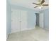 This bedroom has light blue walls, carpet, a closet, and a ceiling fan at 4001 English Valley Dr, Ellenwood, GA 30294
