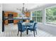 Eat-in kitchen dining area with modern glass table and upholstered chairs adjacent to kitchen with black appliances at 4001 English Valley Dr, Ellenwood, GA 30294