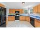 Traditional kitchen featuring wood cabinetry, blue countertops, patterned tile flooring, and modern black appliances at 4001 English Valley Dr, Ellenwood, GA 30294