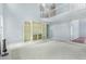 Open-concept living room area with tall ceilings, built-in shelving, carpet and a staircase in the background at 4001 English Valley Dr, Ellenwood, GA 30294