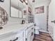 Bathroom featuring a white vanity, framed mirror, wood-look flooring, and decorative details for a rustic charm at 464 Mason Dr, Canton, GA 30115