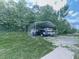 Large metal carport with multiple vehicles parked underneath, surrounded by mature trees at 464 Mason Dr, Canton, GA 30115