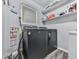 A practical laundry area with a washer, dryer, water heater, and shelving for convenient storage and organization at 464 Mason Dr, Canton, GA 30115