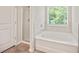 This bright bathroom features a tiled shower and a separate tub with a window view at 5095 Lower Elm St, Atlanta, GA 30349