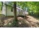 Back exterior featuring a deck surrounded by grass and forest at 545 Willow Creek Dr, Temple, GA 30179