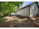 Back exterior with deck in a backyard with a combination of grass and leaves at 545 Willow Creek Dr, Temple, GA 30179