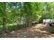 Leafy backyard featuring mature trees and the home's deck at 545 Willow Creek Dr, Temple, GA 30179
