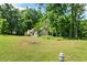 Expansive grassy backyard with mature trees and view of the home's rear exterior at 545 Willow Creek Dr, Temple, GA 30179