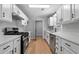 Modern kitchen with white cabinets, stone countertops, stainless steel appliances, and wood-look flooring at 545 Willow Creek Dr, Temple, GA 30179