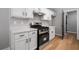 Galley kitchen featuring white cabinetry, new stainless steel appliances, solid surface countertops, and modern lighting at 545 Willow Creek Dr, Temple, GA 30179