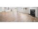 Open floor plan showcasing a fireplace and seamless flow into the kitchen, all featuring stylish wood-look flooring at 1619 Tide Mill Road, Cumming, GA 30040