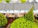 Aerial view of townhome backyards, each with a wooden deck and bordered by mature trees at 1646 Sandy Beach Pt, Lawrenceville, GA 30043