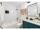 Modern bathroom featuring a shower-tub combo with white subway tile, and a stylish teal vanity with white countertop at 2133 Trailwood Rd, Decatur, GA 30032