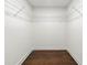 A well organized walk-in closet with white shelving and stained wood flooring at 2133 Trailwood Rd, Decatur, GA 30032