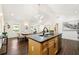 Open concept kitchen with stainless steel appliances, island, and hardwood floors that flows into the dining and living area at 2133 Trailwood Rd, Decatur, GA 30032