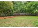 An expansive backyard features green lawn, and is bordered by mature trees and ornamental shrubs at 2700 Vinings Orchard Cir, Atlanta, GA 30339