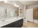 Bathroom featuring double sinks, a large mirror, black cabinets, and a shower with white curtain at 2700 Vinings Orchard Cir, Atlanta, GA 30339