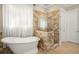 Bright bathroom featuring a soaking tub, glass shower, and neutral tilework at 2700 Vinings Orchard Cir, Atlanta, GA 30339