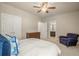 Neutral bedroom with a ceiling fan, a large closet and a blue armchair next to the bathroom door at 2700 Vinings Orchard Cir, Atlanta, GA 30339