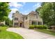Beautiful two-story home with brick and siding exterior, lush landscaping, a two-car garage, and a paved driveway at 2700 Vinings Orchard Cir, Atlanta, GA 30339