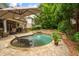 Backyard pool area with stone waterfall, patio, seating, and lush landscaping offers a private outdoor retreat at 2700 Vinings Orchard Cir, Atlanta, GA 30339