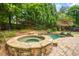 Backyard pool and hot tub with stone surround, waterfall feature, and shade umbrella at 2700 Vinings Orchard Cir, Atlanta, GA 30339